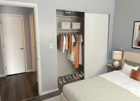 A bedroom with a bed, a wardrobe, and a painting on the wall.