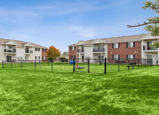 A grassy area in front of apartment buildings.