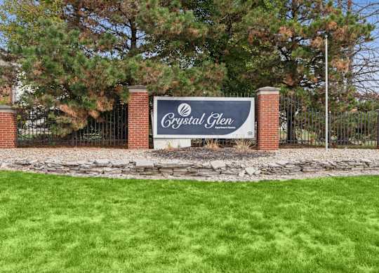 A sign that says Crystal Glen stands in front of a gate.