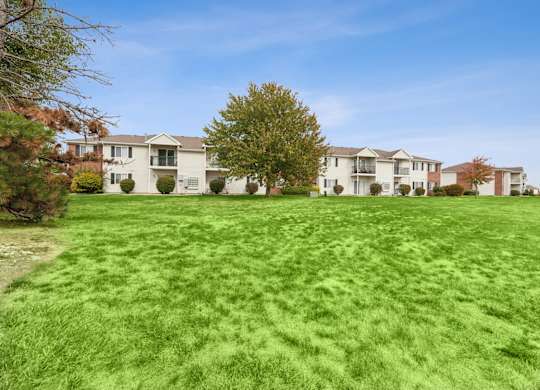 A row of houses with a green lawn in front.