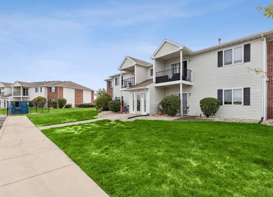 A row of houses with a green lawn in front.