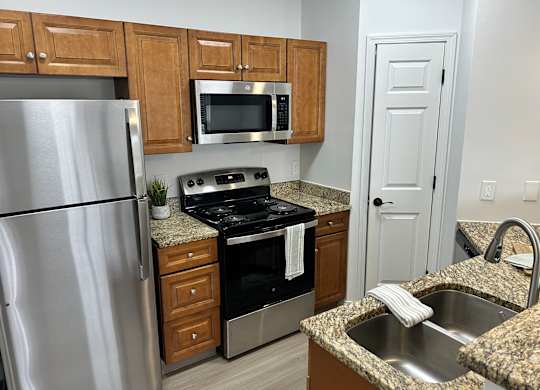 A kitchen with a granite countertop and stainless steel appliances.