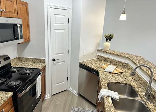 A kitchen with granite countertops and stainless steel appliances.
