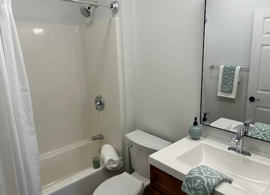A white toilet sits next to a white sink in a bathroom.