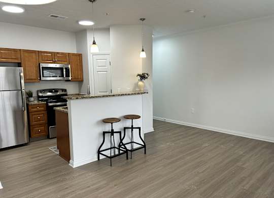 A kitchen with a white counter and bar stools.