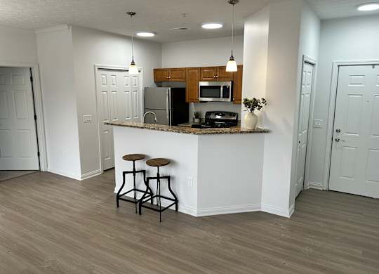 A kitchen with a bar stool in front of it.