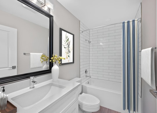 a white bathroom with a large mirror and a tub and a sink at Indian Creek Apartments*, Cincinnati, OH