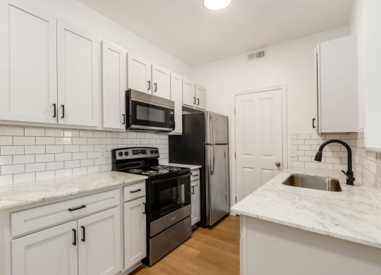 a kitchen with white cabinets and stainless steel appliances