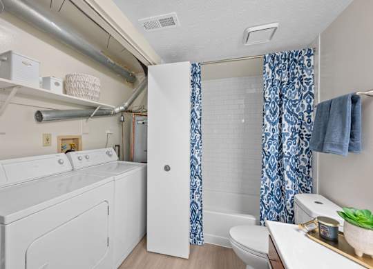 A white washing machine and dryer in a small laundry room.