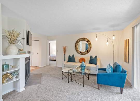 A living room with a blue couch and a fireplace.