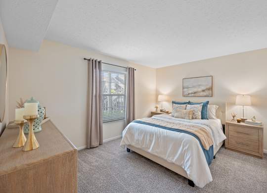 A bedroom with a bed, nightstand, and dresser.