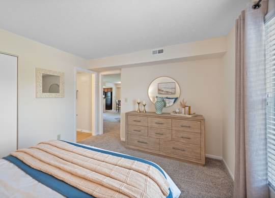 A bedroom with a bed, dresser, and mirror.
