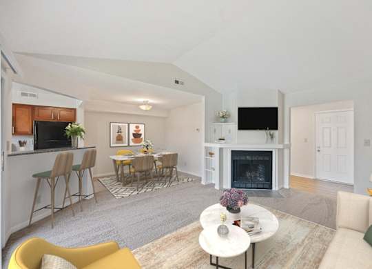 a living room with a fireplace and a table with chairs at Normandy Club Apartments, Centerville
