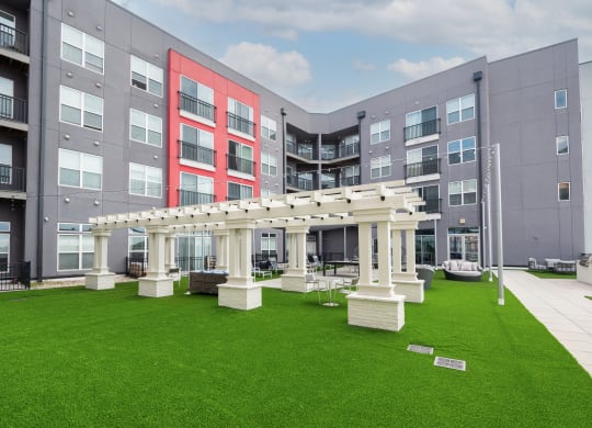 a green lawn in front of an apartment building