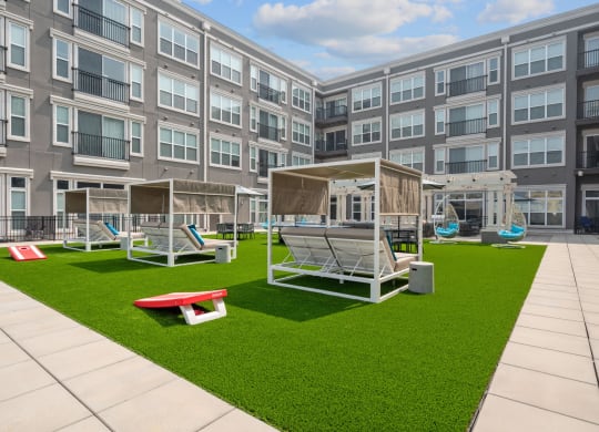 an exterior view of an apartment building with lawn and swing sets