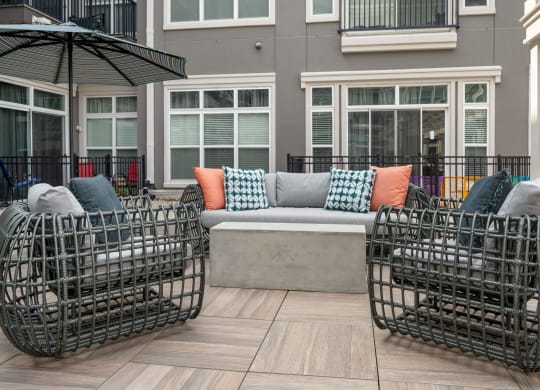 a patio with a couch and chairs and an umbrella