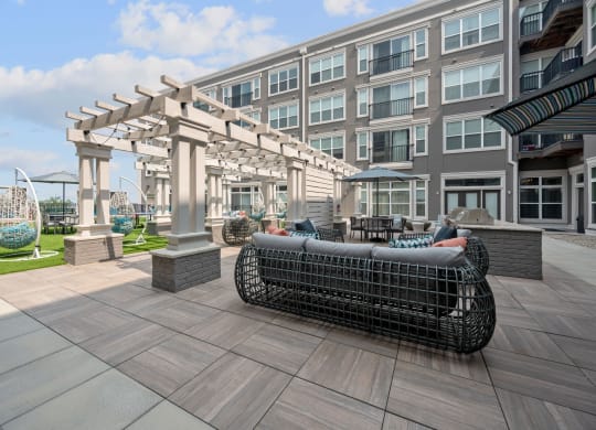 a patio with furniture and a building in the background
