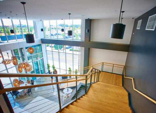 a view down the stairs of a building with a view of a lobby and windows