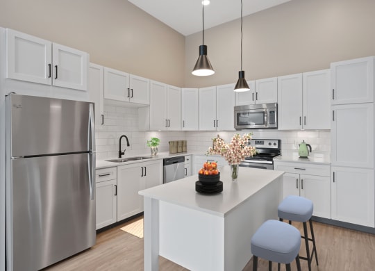 a large white kitchen with stainless steel appliances and a white island