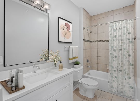 a white bathroom with a shower toilet and sink at Monmouth Row Apartments, Newport, KY, 41071