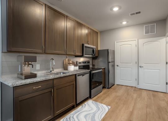 a kitchen with stainless steel appliances and wooden cabinets at Adelphi Quarter, Columbus, OH