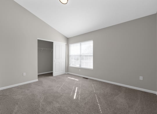 an empty living room with a door to a closet and a window at Traditions at Slate Ridge, Reynoldsburg, 43068