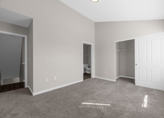 an empty living room with a carpeted floor and a closet at Traditions at Slate Ridge, Reynoldsburg, OH 43068 