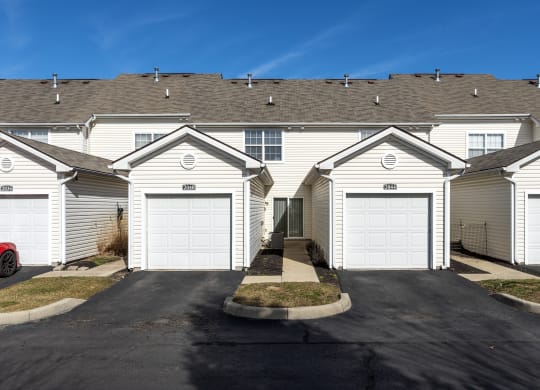 a row of houses with white roofs and garages at Traditions at Slate Ridge, Reynoldsburg