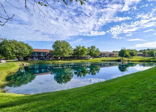 Serene landscape with a pond, trees, and buildings at Meridian Court South, Indiana, 46217