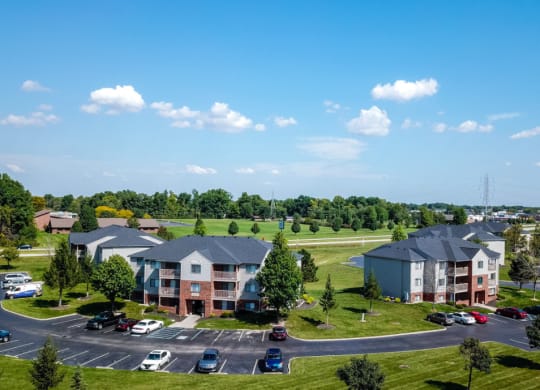 an aerial view of an apartment complex with a parking lot and a lake