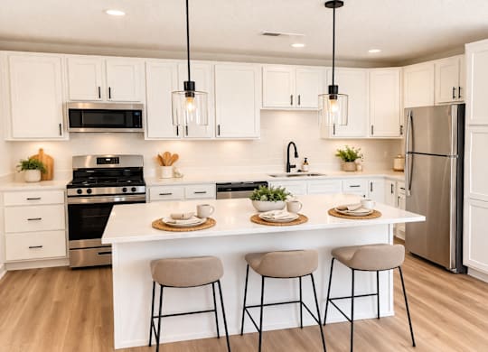 A modern kitchen with white cabinets and a large island.