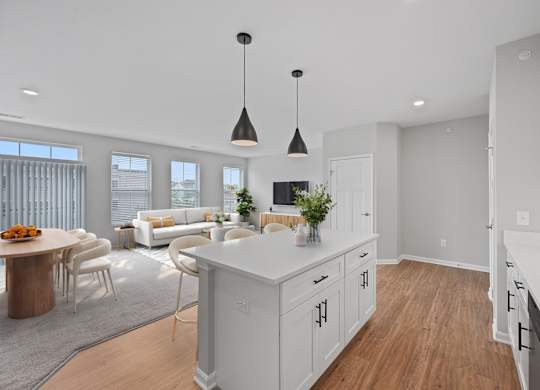 A modern kitchen with white cabinets and a wooden island. at Monmouth Row Apartments, Newport, KY, 41071