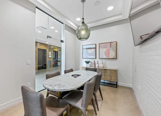Dog-Friendly Apartments in West Chester, OH - Liberty Center - Conference Room with Quartz Table, Glass Doors, and a Mounted Television