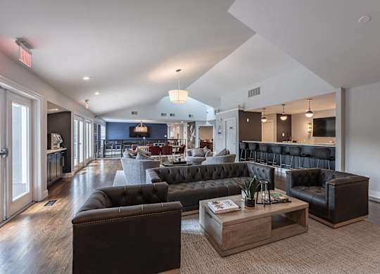 A living room with a black couch and a coffee table.
