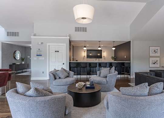 A living room with grey chairs and a black coffee table.