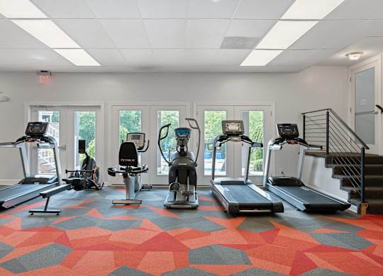 A gym with treadmills and elliptical machines.