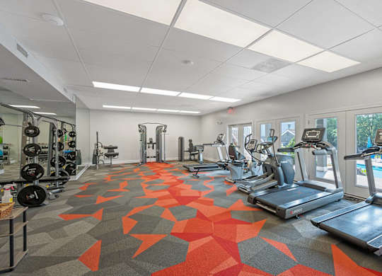 A gym with treadmills, weights, and exercise equipment.