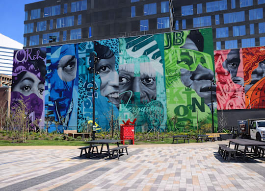 A colorful mural of a woman's face is displayed on a building.