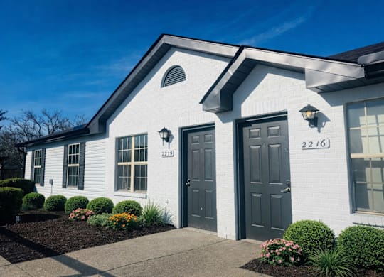 A white house with a black door and windows.
