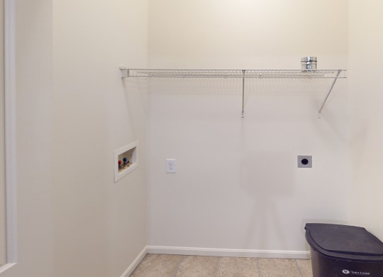 a bathroom with a toilet and a hanging rack on the wall