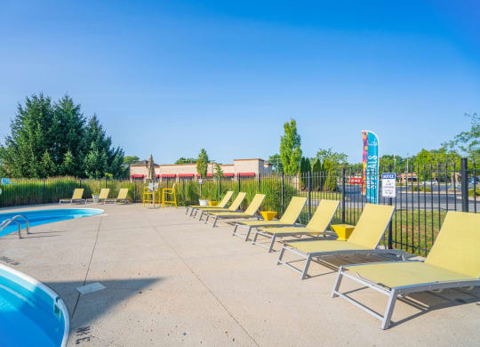 a row of lounge chairs next to a swimming pool at Traditions at Slate Ridge, Reynoldsburg