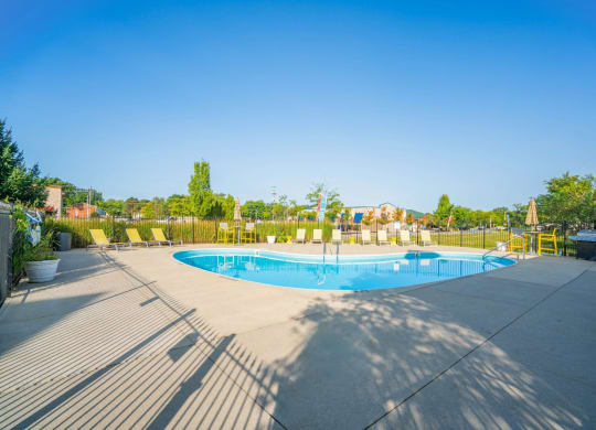a swimming pool with chairs around it on a sunny day at Traditions at Slate Ridge, Ohio