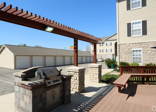 a covered patio with a grill and a picnic table