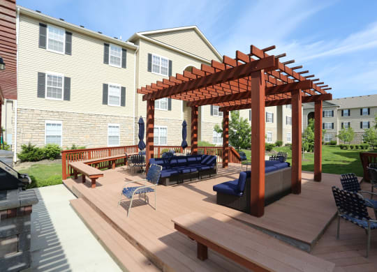 a backyard patio with a wooden deck and a pergola