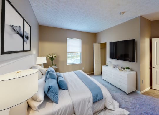 a bedroom with a bed and a dresser and a tv