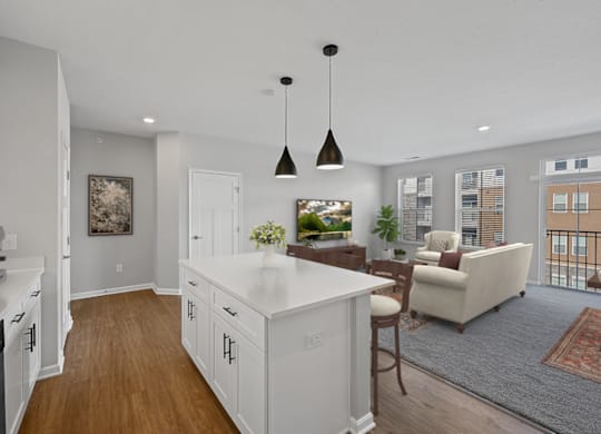 an open kitchen and living room with white cabinets and a white counter top at Monmouth Row Apartments, Newport, KY, 41071