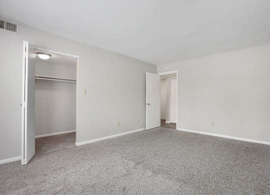 A room with a grey carpet and white walls.