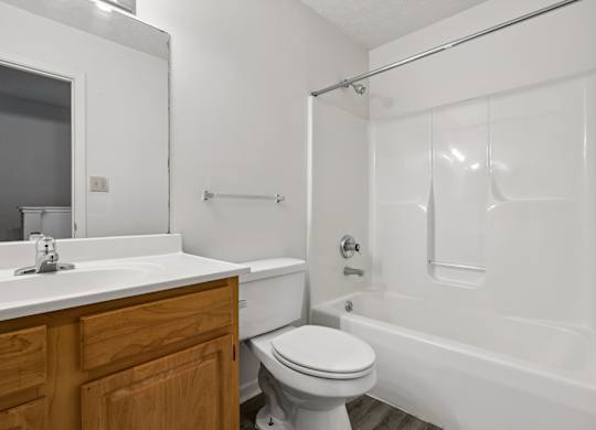 A white bathroom with a toilet, sink, and bathtub.
