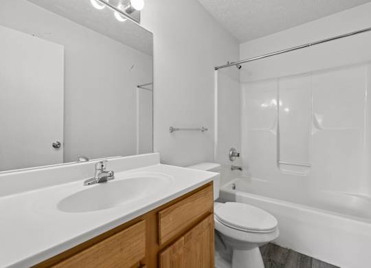 A white bathroom with a sink, toilet, and bathtub.