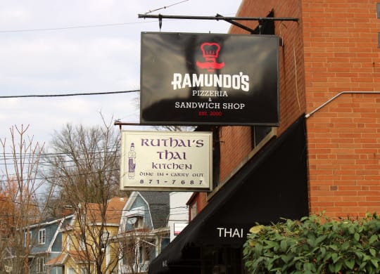 a sign for a restaurant on the side of a brick building